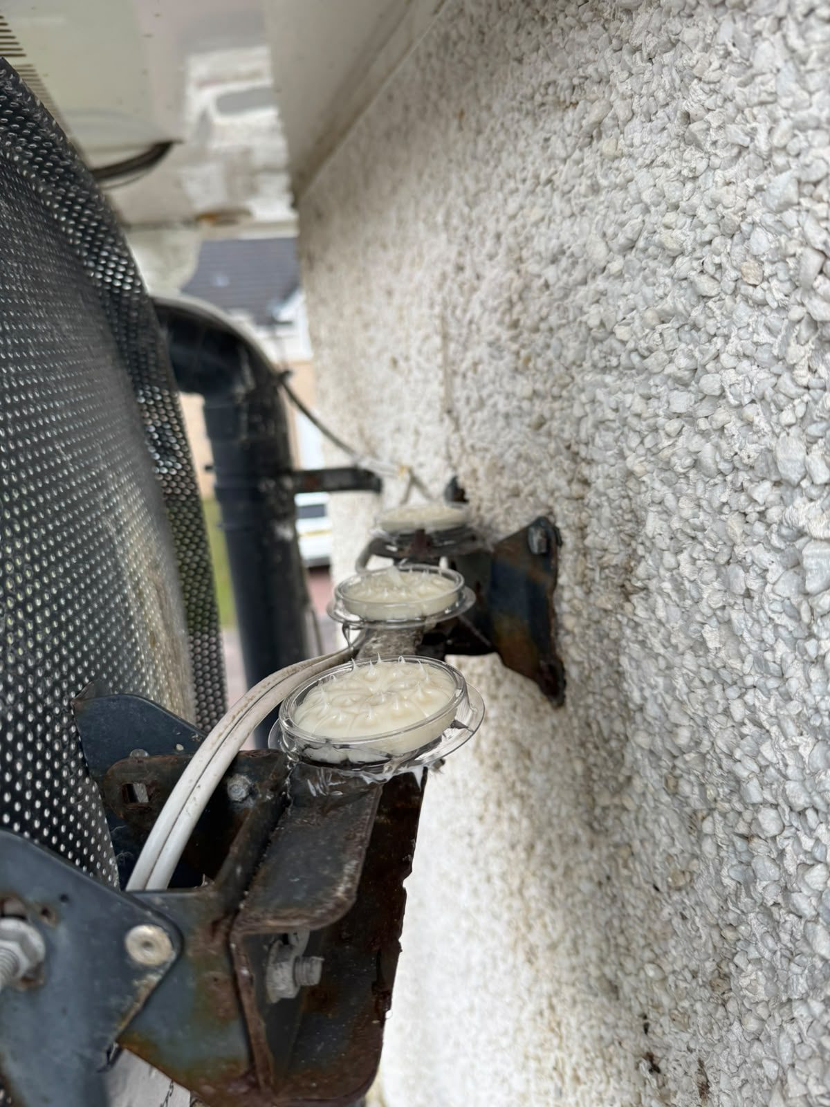 Bird deterrent gel dishes installed beside rooftop building equipment