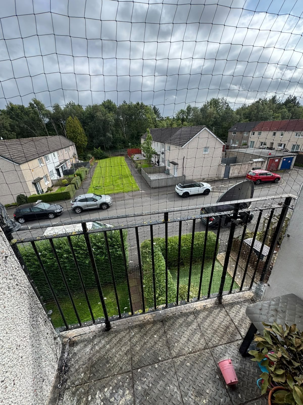 Bird netting over a residential courtyard and roofline