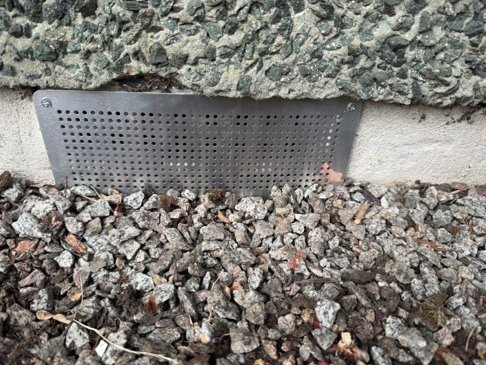 Stainless steel vent cover fitted to block rodent entry at ground level