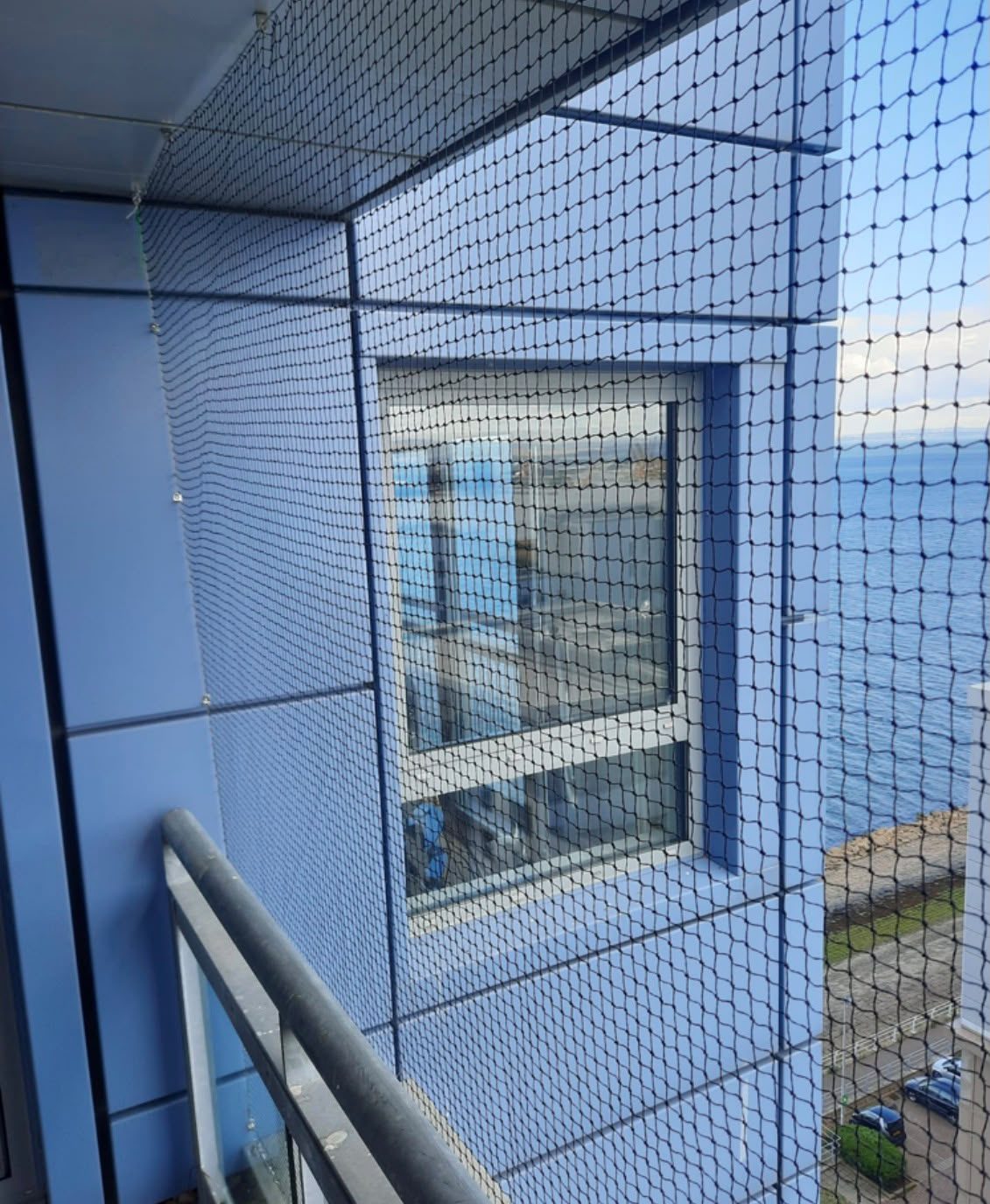 Bird netting enclosing a high-rise balcony to prevent pigeon roosting