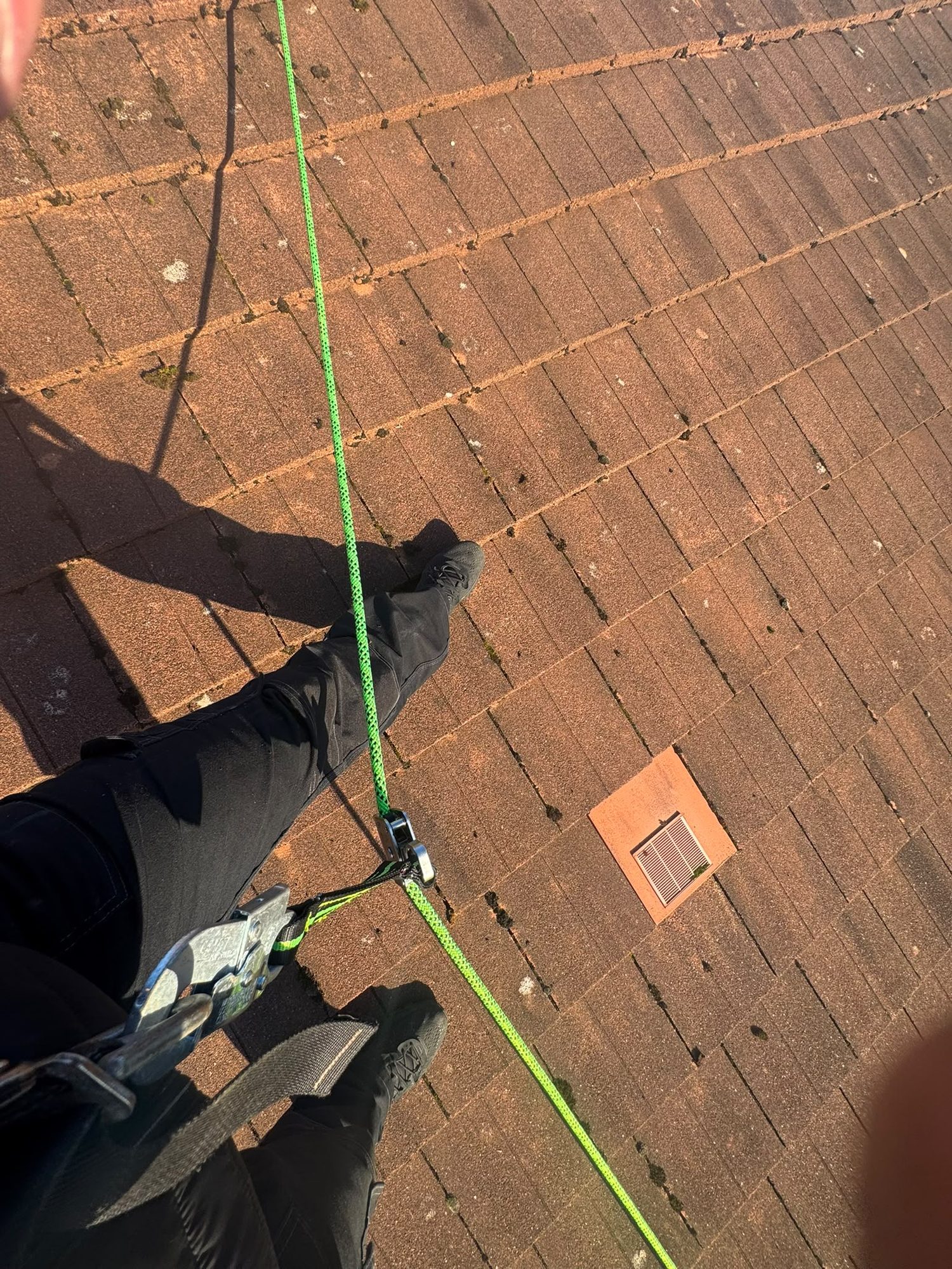 Technician working at height with rope access on a Glasgow roof
