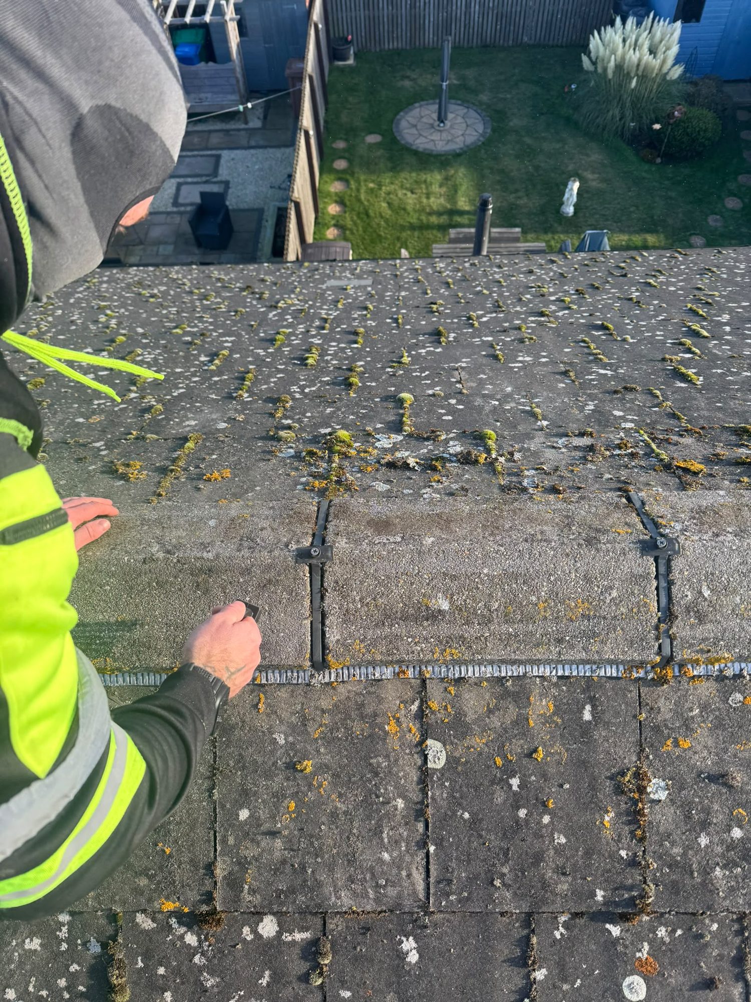 Technician inspecting moss and bird fouling on a Glasgow roof